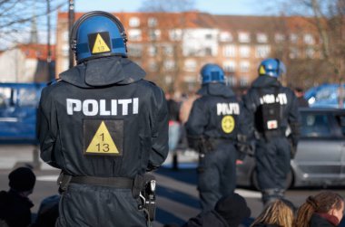 Emniyet, barış ve kalabalığı kontrol altına almak için emniyet, koruma ya da güvenlik için şehirde polis var. Danimarka sokaklarında toplanan cesur, üniformalı ve isyancı insan hakları savunucusu.