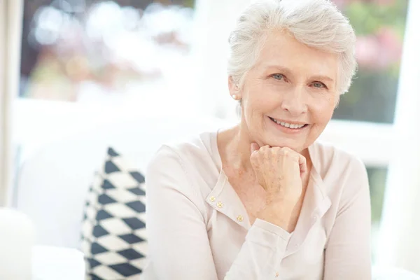 优雅地衰老的秘诀是享受它 一个快乐的老年妇女在家里享受放松的一天的画像 — 图库照片