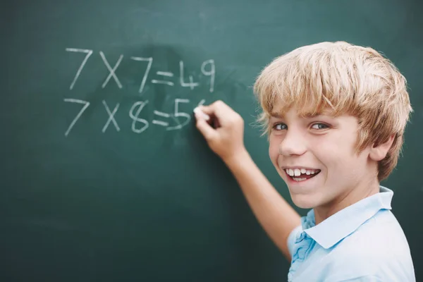 彼の合計を行うことに興奮した 若い男の子がチョークで黒板に金額を書いている Copyspace — ストック写真