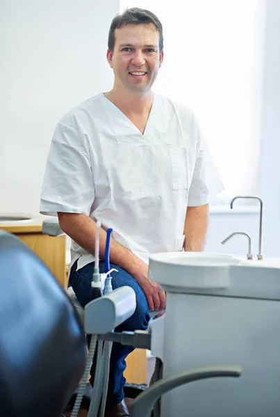君の優しい歯医者だ 彼のオフィスの歯科機器によって座っている男性歯科医の肖像画 — ストック写真