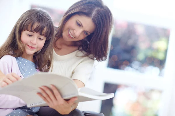 読書は彼女の好きな娯楽である 母親と娘が一緒に本を読んで — ストック写真