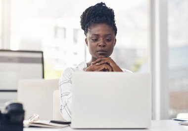Tutkuna zaman ayır. Çekici genç bir iş kadını ofisinde yalnız oturuyor ve laptopunu kullanırken düşünceli görünüyor.