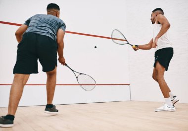 İçinden gelerek çal. İki genç adam squash oynuyor.