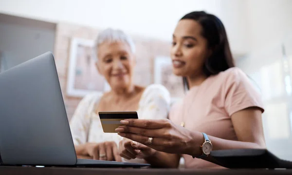 Stock image Lets keep an eye on that credit limit. a senior woman using a laptop and credit card with her daughter at home