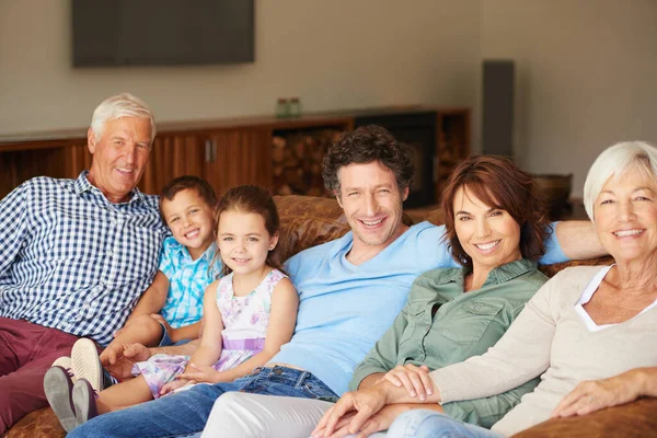 家庭は最高の祝福です 幸せな多世代の家族がソファに座って — ストック写真