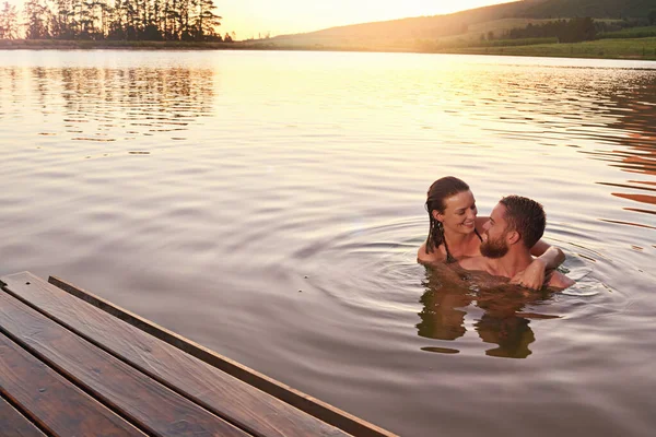 日没のディップを楽しむ 湖で一緒に泳ぐのを楽しんでいる愛情のある若いカップルは — ストック写真