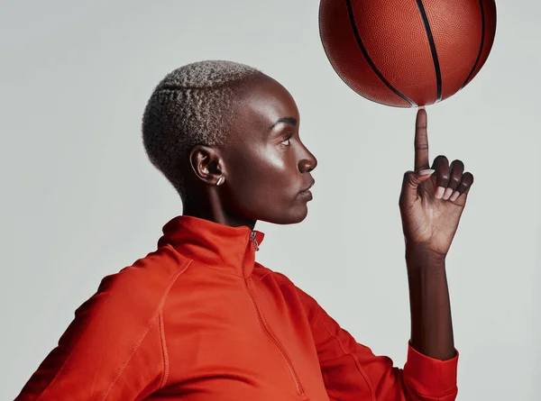 If you can do this, youre a natural. Studio shot of an attractive young woman playing basketball against a grey background