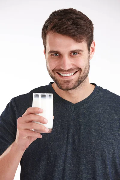 カルシウムレベルを維持する ミルクのグラスを持った笑顔の男のスタジオポートレート — ストック写真