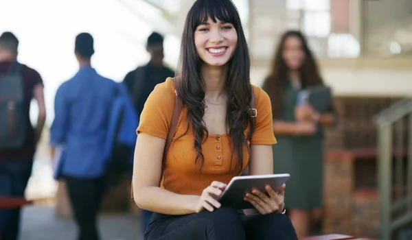 生活就是学习 一个快乐的年轻学生白天在学校外面等着上课时在她的数码平板电脑上浏览的肖像 — 图库照片
