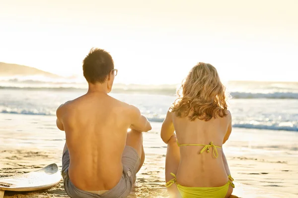 最も平和的な場所 海を眺めながらビーチに座っている若いカップルのレビューショット — ストック写真