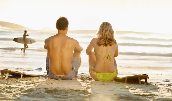 リラックスするのが一番です 海を眺めながらビーチに座っている若いカップルのレビューショット — ストック写真
