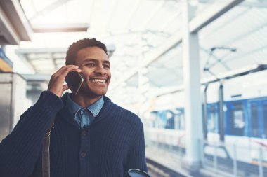 Başarı bir anda olmaz, ona ulaşmak zorundasındır. Metroda yürürken cep telefonu kullanan genç bir işadamı.