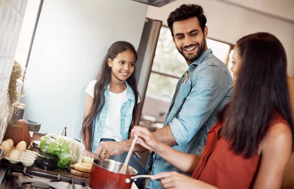 他们一起做饭比较好 一个快乐的年轻家庭在厨房里和家人一起做饭 — 图库照片