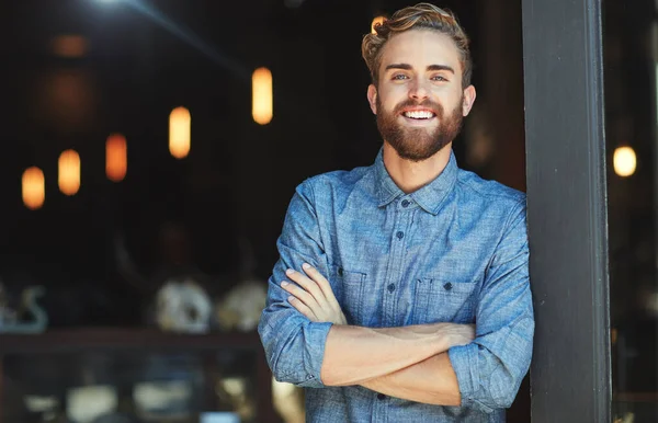 Portrait, happy and man in a cafe, arms crossed and startup success with employment, business owner or joyful. Face, male employee or confident entrepreneur with a smile, coffee shop and professional.