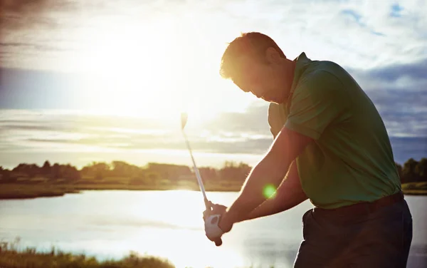 ゴルフの技術を習得している ゴルフ場でスイングの練習をしている男が — ストック写真