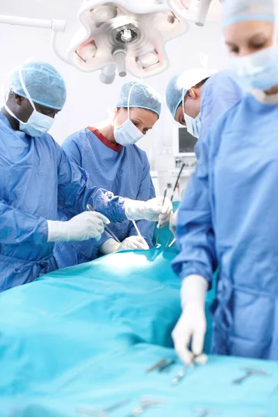 在手术台上一组外科医生在手术中看着手术台上的病人 — 图库照片