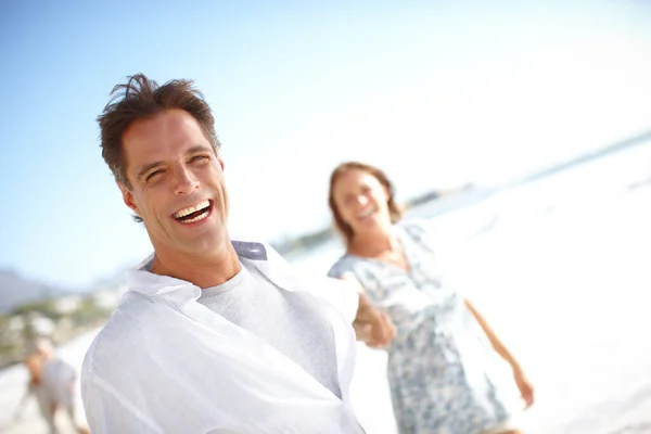 彼が行くところで彼女は続くだろう 一緒にビーチを歩いている間に手で彼女の夫を率いる幸せな成熟した女性の肖像画 — ストック写真