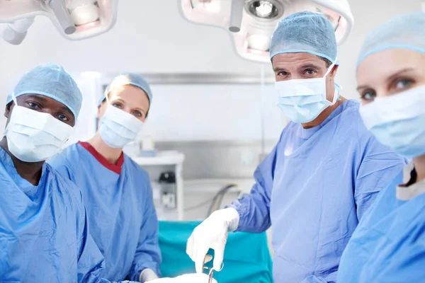 相信我们的团队会照顾好你所爱的人在手术室工作的一组不同的外科医生的画像 — 图库照片