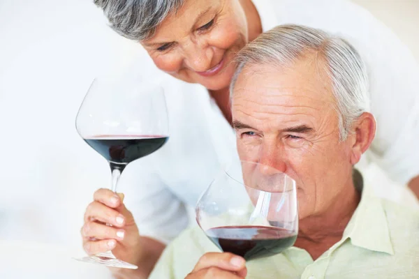 大人の夫婦がワインを飲む 自宅でワインを飲みながら笑顔の美しい成熟したカップルの閉鎖 — ストック写真