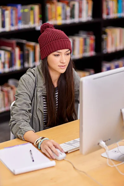 彼女は勉強するための静かな場所を見つけた 大学図書館でコンピュータを研究している女子学生が — ストック写真