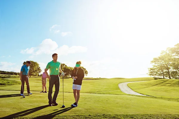 和朋友一起在球道上 在阳光灿烂的日子里 两对夫妇一起打了一圈高尔夫球 — 图库照片