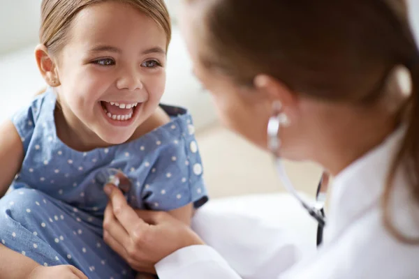幸せな子供 女の子と医師の聴診器 健康的な肺やハートビートに耳を傾けます 笑う子供の顔 診療所での医療分析のための小児科医と胸の評価 — ストック写真