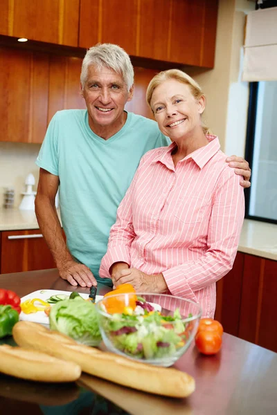 粘在厨房里一对老夫妇在厨房里准备沙拉的肖像 — 图库照片