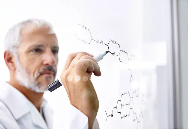 严重的化学键 在玻璃表面画化学键的成熟男性科学家 — 图库照片