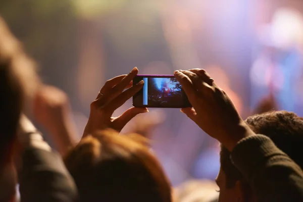 stock image Music, concert and phone camera in the audience to record a performance on stage at a festival or event. Party, video or photograph with a person in the crowd of a stadium at night holding a mobile.