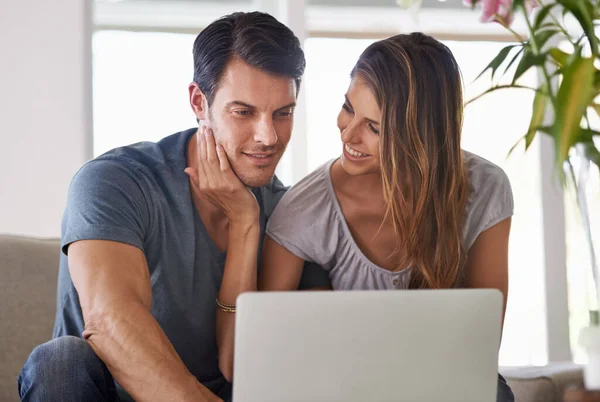 幸せな結婚した男のブログ 妻とソファに座っている間にノートパソコンを使っている若い男 — ストック写真