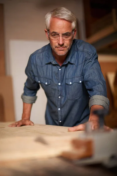 他的作品达到了最高标准 一个成熟的男性木匠在他的车间里做一个项目 — 图库照片