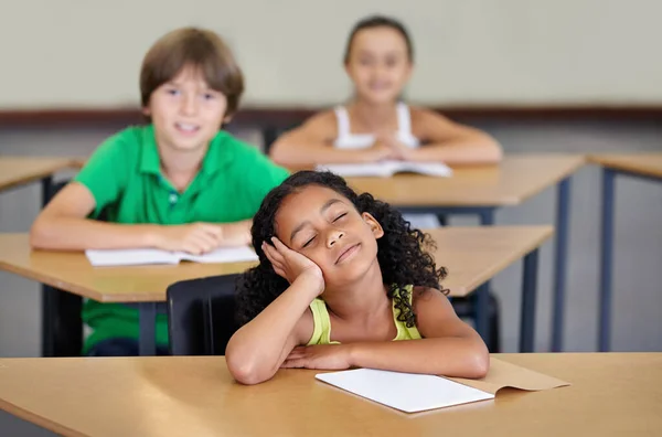 学校快把她累坏了 一个看起来很无聊的少数民族女孩坐在她的课桌前 — 图库照片