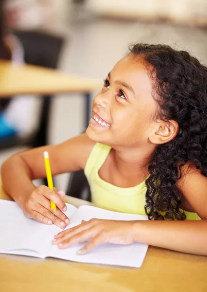 学校和孩子在她的书中写作 同时在课堂上听一节课 在课桌边做教育活动 学习或做作业的快乐 微笑和年轻的女学生 — 图库照片