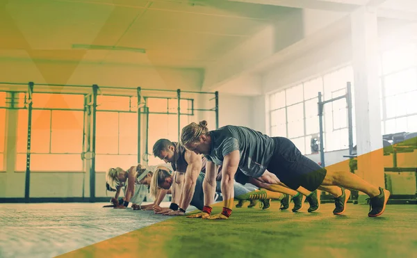 stock image Fitness, gym and group push up exercise, workout and training in class. Sports men and women together in row for power challenge, energy or strong muscle at health and wellness club with overlay.