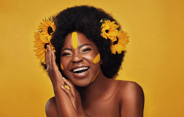 stock image Portrait, smile and black woman with sunflowers in her hair, makeup and confident girl against a studio background. Face, female person and model with cosmetics, funny and natural care with happiness.