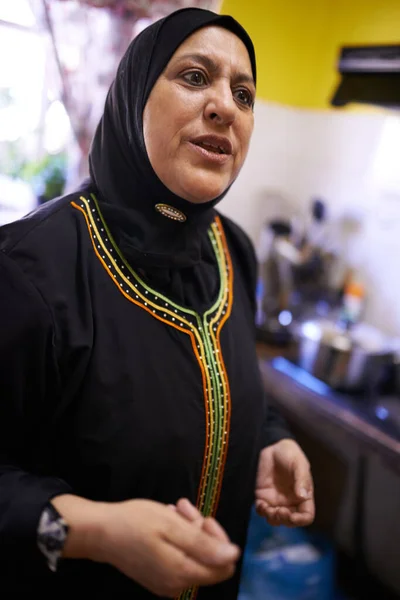 我的厨房是我尽我最大努力的地方 厨房里一个成熟的穆斯林妇女 — 图库照片