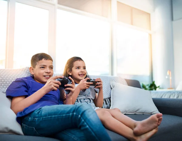 경쟁적 이었다 자녀가 소파에 앉아서 집에서 비디오 게임을 — 스톡 사진