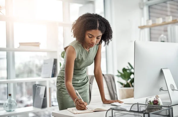 stock image Computer, planning and business woman writing and working by her desk or table in a corporate startup company. Internet, online and professional female employee or African worker with a schedule book.