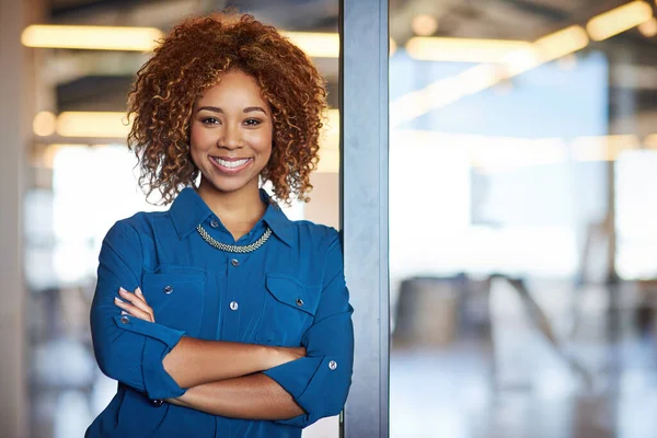 Corporate, portrait of young black woman with arms crossed and in a modern office at work. Success, entrepreneur and a confident happy African female worker standing at doorway at workplace
