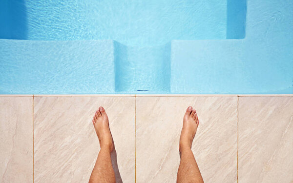 Water, feet and pov of man at a pool for swimming, leisure and summer, fun and relax. Barefoot, swimmer and legs of male person at poolside on holiday, vacation or enjoying a weekend swim outdoor.