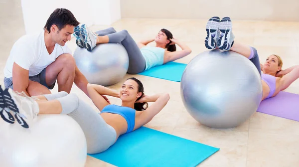 私人教练 普拉提和球 以帮助妇女在平衡 姿势和快乐的训练 健身和健身房 在课堂上做运动 帮助女性做伸展运动 健康运动或在地板上锻炼 — 图库照片