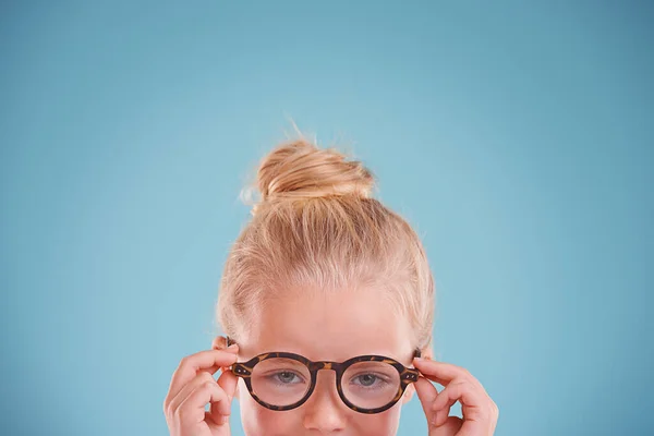 多亏了她的新眼镜 工作室拍摄的一个蓝色背景的小女孩戴着嬉皮士眼镜的照片 — 图库照片