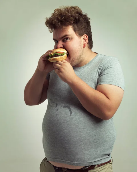 バーガーの近くに来るな スタジオショットの太りすぎの男のハンバーガーにかむ — ストック写真