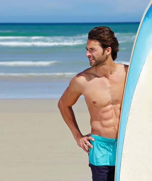 ビーチで一日 サーフボードの横に立っている若い男が — ストック写真
