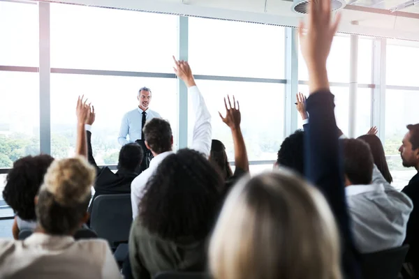 stock image Feel free to ask as many questions. a group of businesspeople raising their hands during a presentation