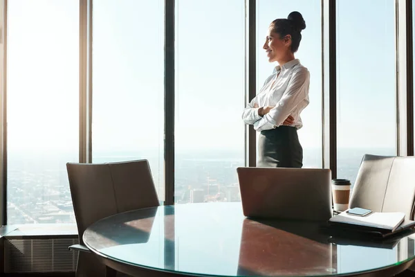 stock image Big ambitions are always running through her mind. a young businesswoman looking out the window in an office