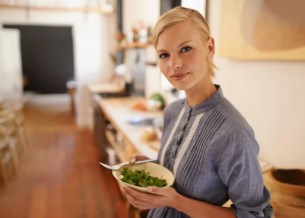 私はいつも健康です 素朴なキッチンで緑豊かな緑のボウルを保持している若い女性の肖像画 — ストック写真