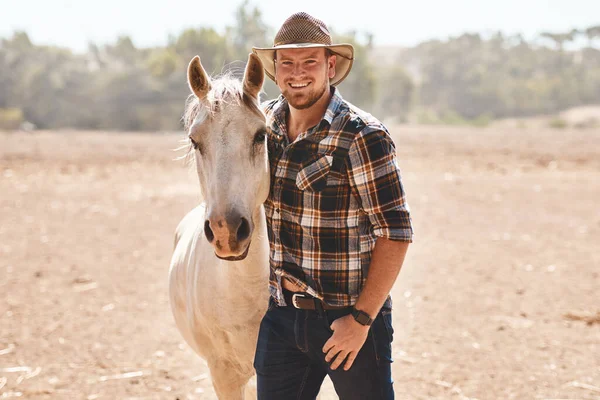 stock image My herd have lots of ground to roam on this farm. Portrait of a farmer standing with a horse on a ranch