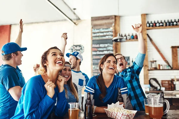 stock image Go, team, go. a group of friends cheering while watching a sports game at a bar