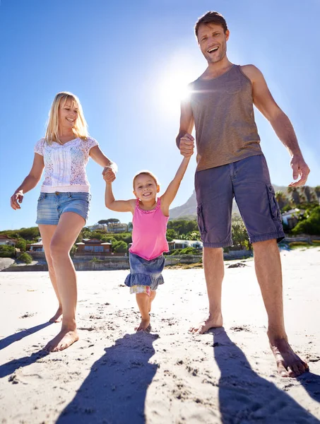 ビーチは私たちの好きな目的地です ビーチで散歩を楽しむ幸せな若い家族の完全な長さのショット — ストック写真